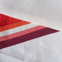 Load image into Gallery viewer, Lesbian Flag FPP quilt block pattern laid out with vibrant fabric strips